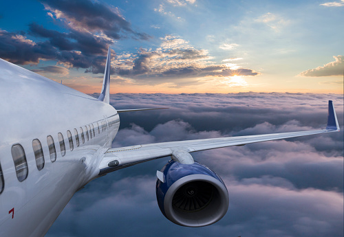 Body of an Airplane Flying Through Clouds at sunset