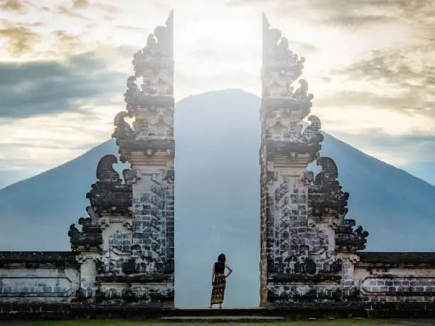 Traveler standing at the ancient gates of Pura Luhur Lempuyang temple aka Gates of Heaven in Bali, Indonesia.