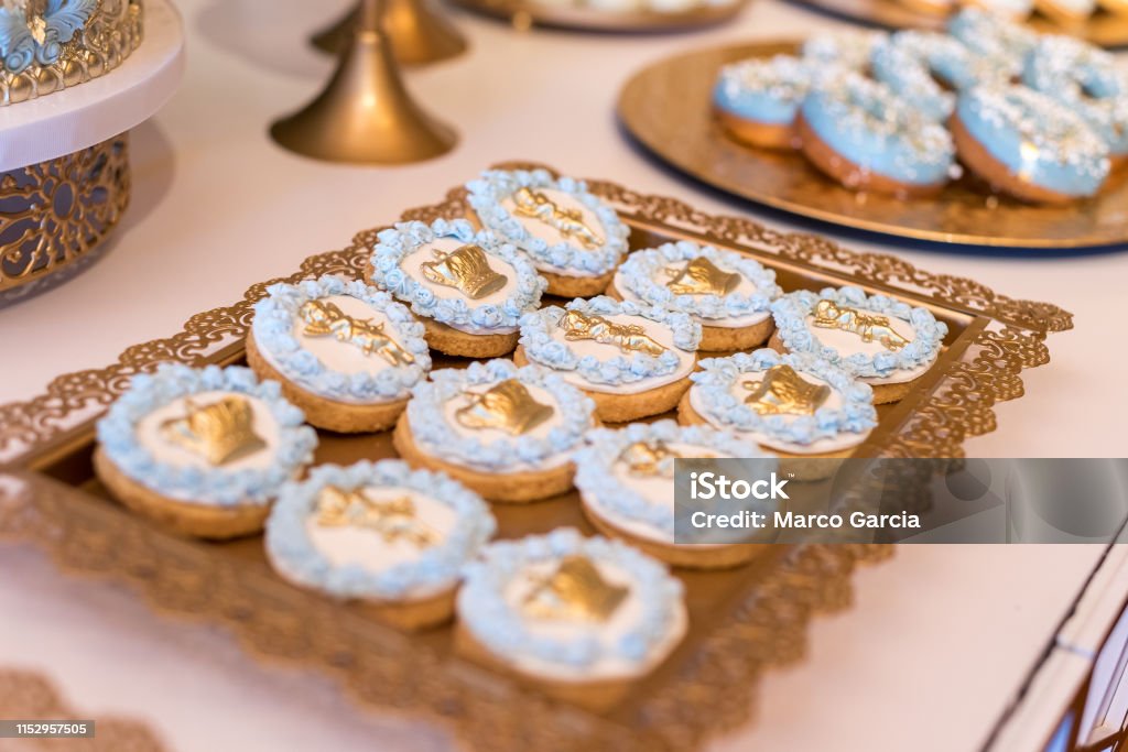 Cookies with blue and golden decoration on golden tray Cookies with blue and golden decoration on golden tray. Cookies decorated with crowns and angels. Ideal for religious celebrations or boys party decoration Baked Stock Photo