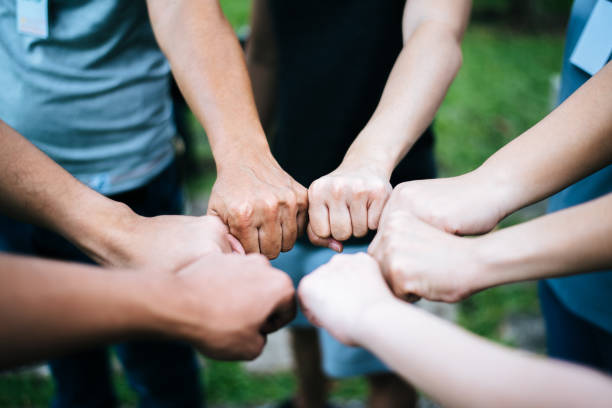 istock Close up of students standing hands making fist bump gesture. 1152959479