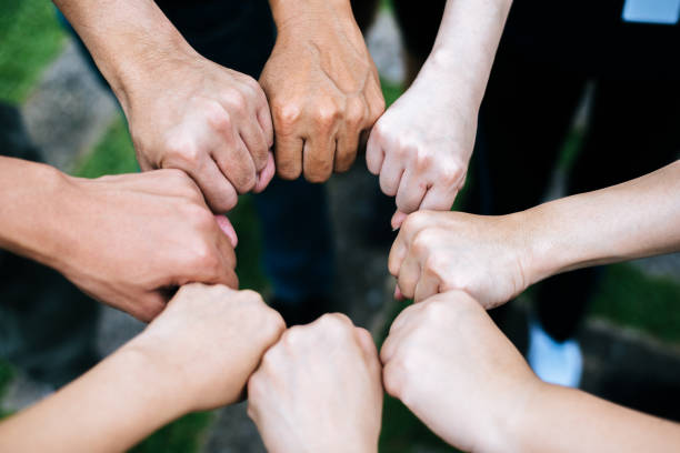 istock Close up of students standing hands making fist bump gesture. 1152959540
