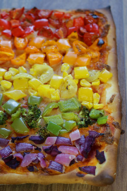 istock Image of rectangular rainbow pizza recipe dish kids family meal, homemade rectangle veggie pizza rainbow healthy eating vegetables toppings, mozzarella cheese, pizzeria meal Italian restaurant topped tomatoes, peppers, sweetcorn, broccoli, onions, cabbage 1152960652