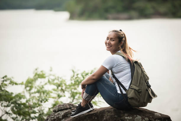 istock Young woman with backpack sitting enjoy with forest. Travel concept. 1152974138