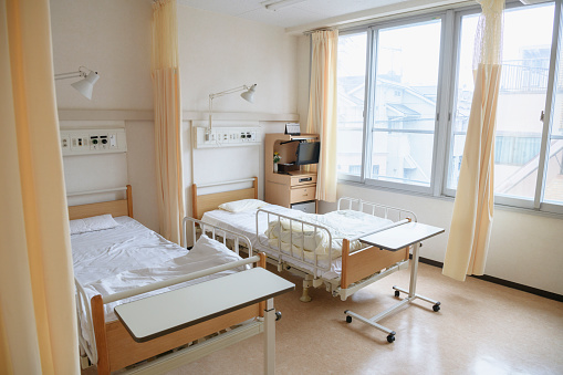 Pale coloured hospital room with empty beds, waiting for patients, modern, clean, bright