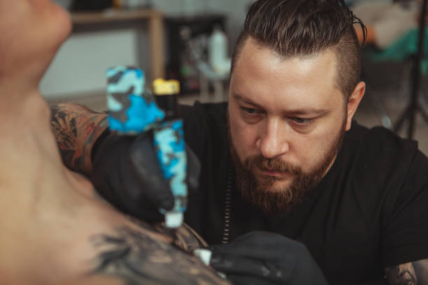 istock Man getting new tattoo by professional tattooist 1152975077