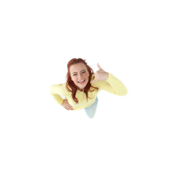 istock Young female in yellow sweater looking up cheering 1152975139