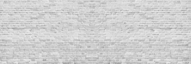 Wide white washed brick wall texture. Rough light gray vintage brickwork. Whitewashed panoramic background