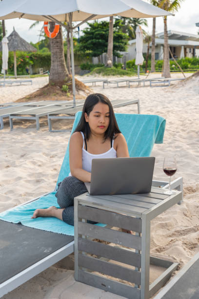 istock Young Asian freelancer working with laptop on the beach 1152979497