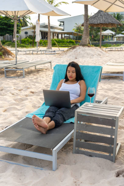 istock Young Asian freelancer working on laptop at the beach 1152979552