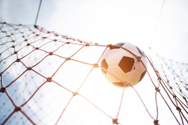The closeup image of the soccer goal net shows its hexagonal mesh structure against a vibrant green background, highlighting its importance in scoring during soccer matches
