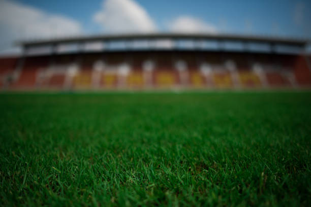 istock Stadium background with a green grass pitch in the daytime 1152986770