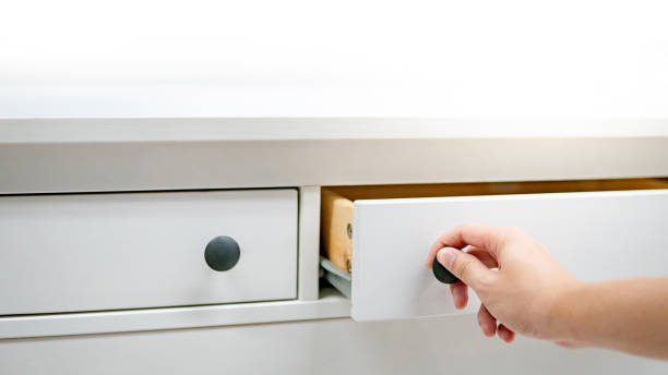 istock Male hand opening drawer on white cabinet 1152990537
