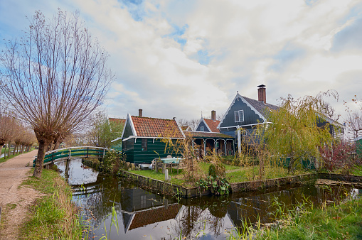 Backyard of one of the houses in the area. surrounded by a canal, and with garden furniture.\n\nTourist area of Zaandam, in the Netherlands.\nPhoto taken in autumn.\n03/12/2018\nzaanse schans