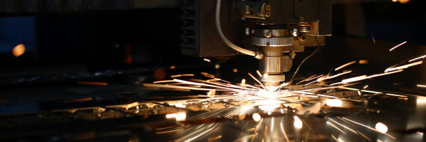 Sparks fly out machine head for metal processing Sparks fly out machine head for metal processing laser metal on metallurgical plant background. Manufacturing finished parts for automotive production concept laser cutting metal stock pictures, royalty-free photos & images