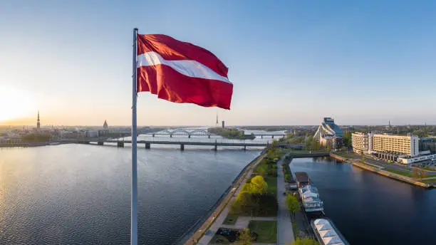 Picture from a drone of the huge Latvian flag above AB dam taken on an early spring morning whilst the sun is rising. River Daugava with it's bridges can be seen on the left.