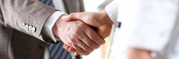 istock Man in suit and tie give hand as hello in office 1153000225