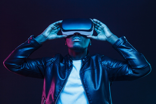 istock Hombre afroamericano en gafas VR, viendo video de 360 grados con cascos de realidad virtual aislados en fondo negro 1153003853