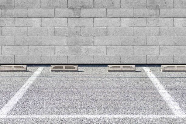 istock Empty Outdoor car parking space and stone block wall 1153005036