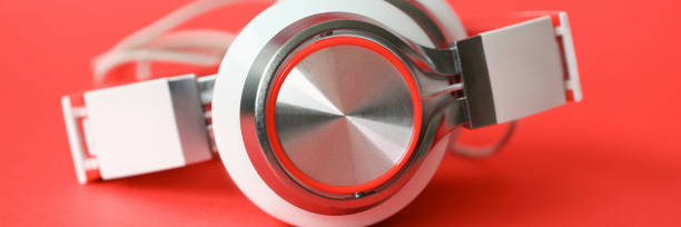 istock White headphones on coral background 1153005651