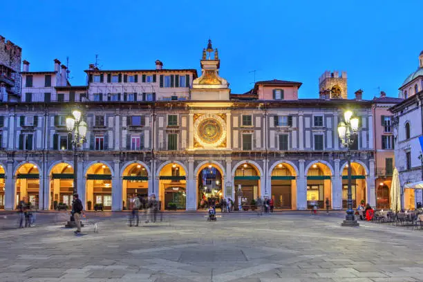Twilight scene in Piazza della Loggia, Brescia, Italy featuring the Astronomical Tower on its east side.