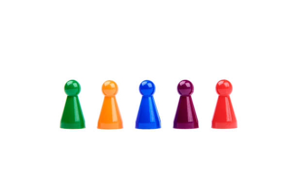 istock Five plastic toys - playing pieces with different colors as diverse team standing in a row - isolated on white background 1153006966