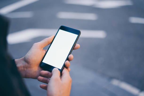 istock Closeup image of male hand holding smartphone with blank screen. Mockup ready for text message or content. Man's hands with cellphone. Empty display. Night street, bokeh light 1153010861