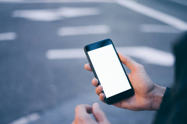 istock Closeup image of male hand holding smartphone with blank screen. Mockup ready for text message or content. Man's hands with cellphone. Empty display. Night street, bokeh light 1153010867