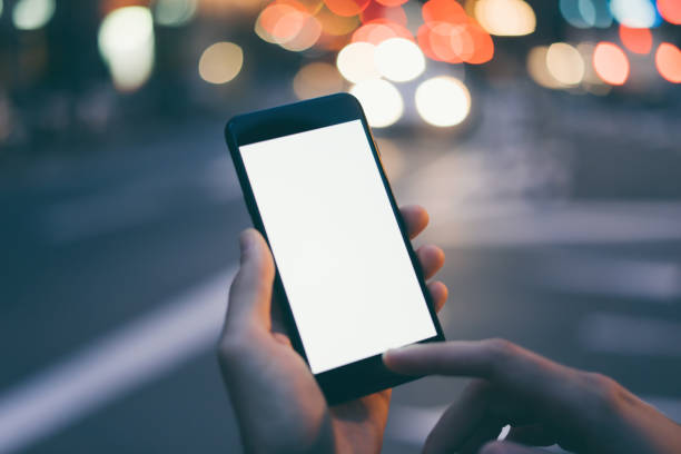 istock Closeup image of male hand holding smartphone with blank screen. Mockup ready for text message or content. Man's hands with cellphone. Empty display. Night street, bokeh light 1153010901