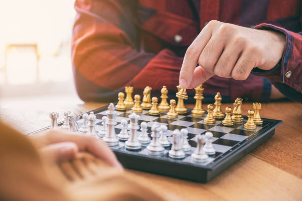 istock Closeup image of a man moving and playing chessboard game together 1153011434