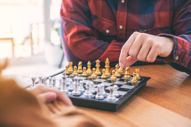 istock Closeup image of a man moving and playing chessboard game together 1153011453