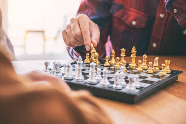 istock Closeup image of a man moving and playing chessboard game together 1153011454