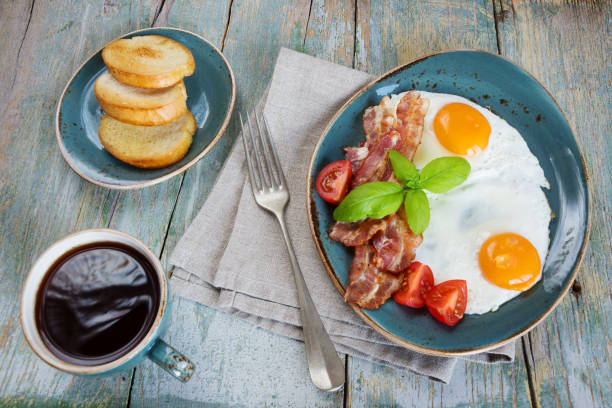 istock Fried eggs,  bacon, tomato, toast and a cup of coffee 1153013712