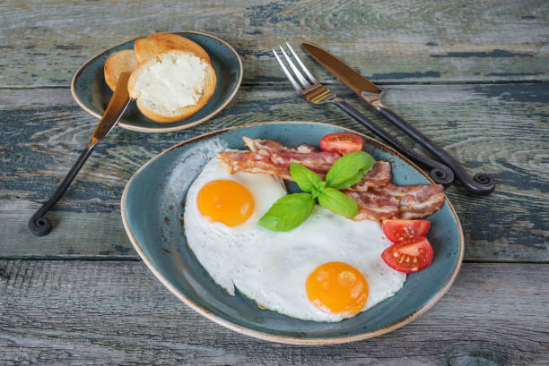 Fried eggs,  bacon, tomato, toast and butter