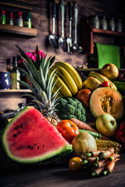 istock Assorted tropical fruits and vegetables in a rustic kitchen. Natural lighting 1153014781