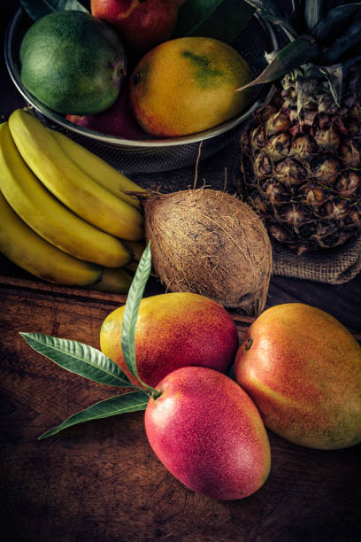 istock Assorted tropical fruits and mangos in rustic kitchen. Natural lighting 1153015469