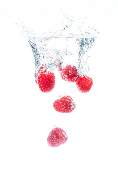 himbeeren fallen in kristallklares wasser. - falling fruit berry fruit raspberry stock-fotos und bilder