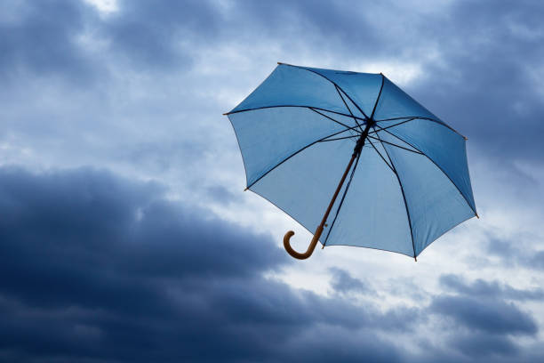 istock flying umbrella against a blue cloudy sky 1153019538