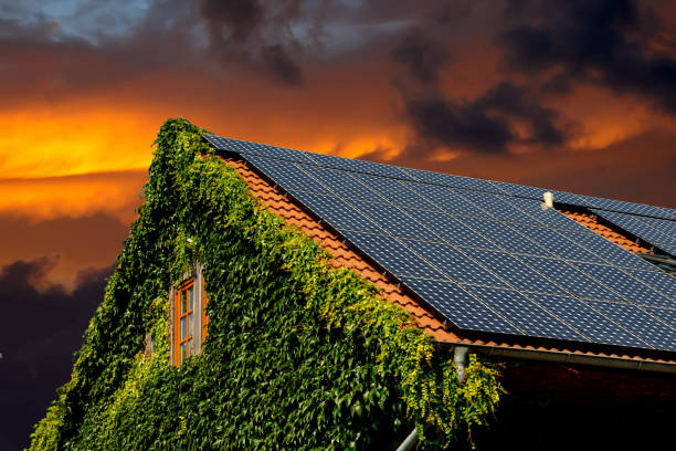 A beautiful dawn and solar panels on a house rooftop.