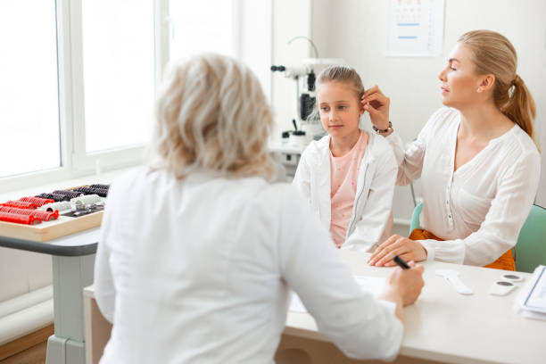 istock Caring long-haired mother visiting doctor with her daughter 1153021734