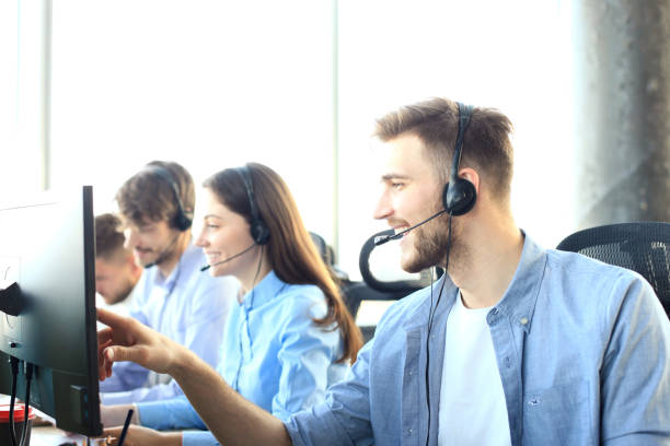 istock Portrait of call center worker accompanied by his team. Smiling customer support operator at work. 1153023005