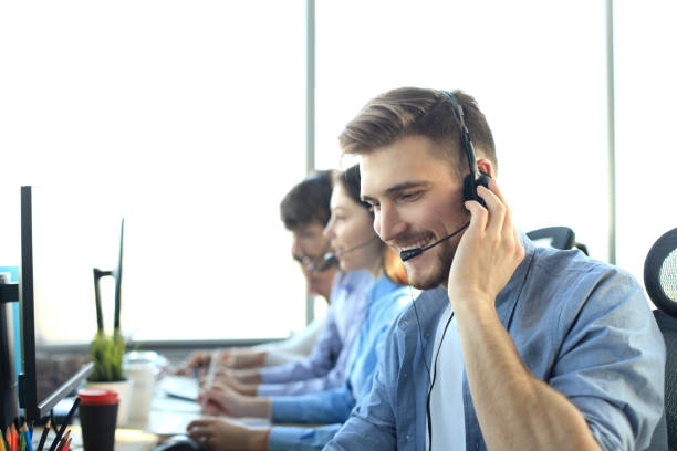 istock Portrait of call center worker accompanied by his team. Smiling customer support operator at work. 1153023893