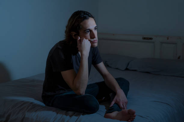 istock Devastated millennial man crying sad feeling hurt and hopeless suffering Depression. Depressed teenager victim of bullying or abuse sitting on bed alone in despair at night. In teenage Mental health. 1153024086