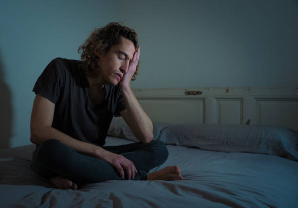 istock Devastated millennial man crying sad feeling hurt and hopeless suffering Depression. Depressed teenager victim of bullying or abuse sitting on bed alone in despair at night. In teenage Mental health. 1153024098