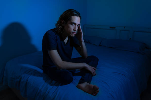 istock Devastated millennial man crying sad feeling hurt and hopeless suffering Depression. Depressed teenager victim of bullying or abuse sitting on bed alone in despair at night. In teenage Mental health. 1153024195