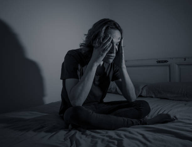 istock Devastated millennial man crying sad feeling hurt and hopeless suffering Depression. Depressed teenager victim of bullying or abuse sitting on bed alone in despair at night. In teenage Mental health. 1153024207