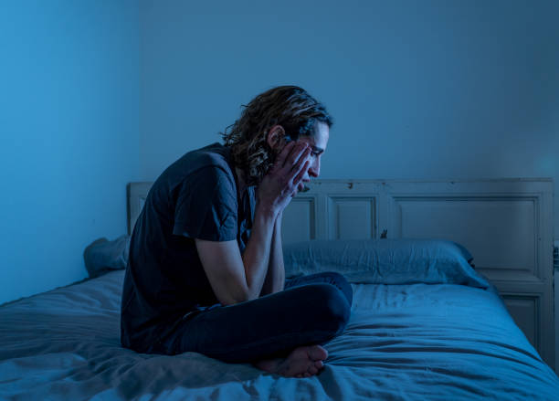 istock Devastated millennial man crying sad feeling hurt and hopeless suffering Depression. Depressed teenager victim of bullying or abuse sitting on bed alone in despair at night. In teenage Mental health. 1153024215