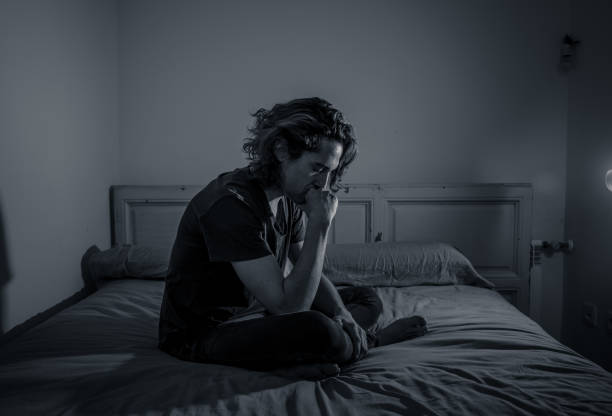 istock Devastated millennial man crying sad feeling hurt and hopeless suffering Depression. Depressed teenager victim of bullying or abuse sitting on bed alone in despair at night. In teenage Mental health. 1153024245