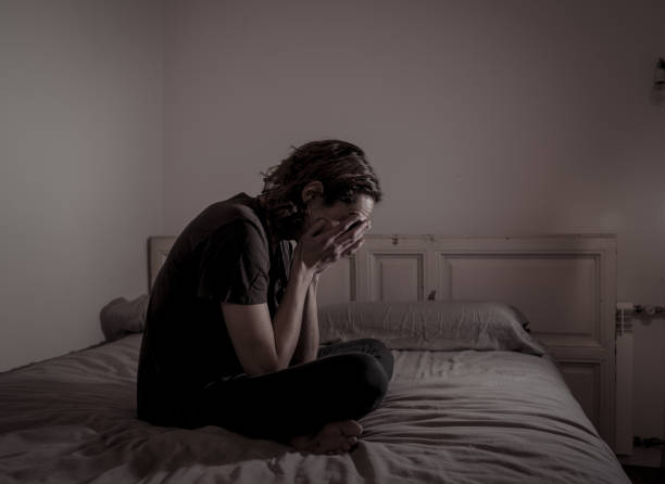 istock Devastated millennial man crying sad feeling hurt and hopeless suffering Depression. Depressed teenager victim of bullying or abuse sitting on bed alone in despair at night. In teenage Mental health. 1153024313