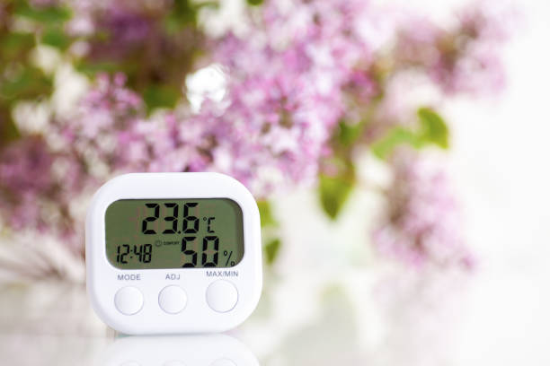 Hygrometer on a table Electronic hygrometer-thermometer shows comfort temperature and humidity. hygrometer photos stock pictures, royalty-free photos & images
