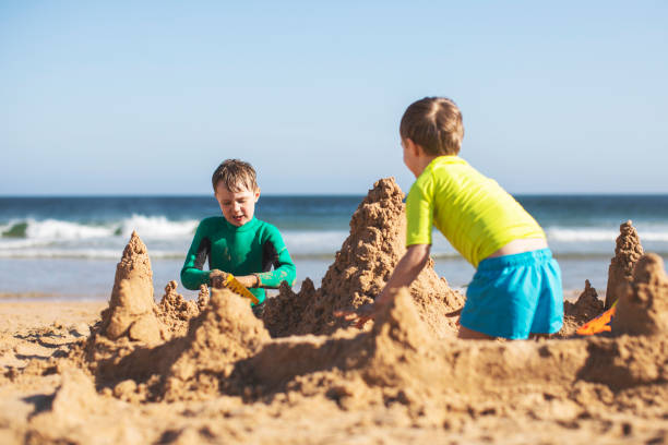 istock Kids building sand castle 1153026698